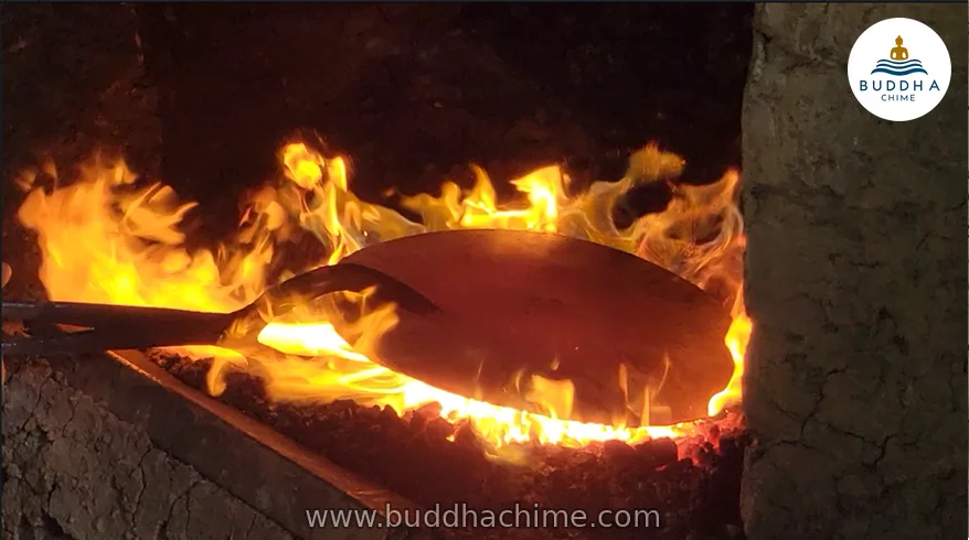 Singing bowl glowing red-hot in the forge fire in Nepal