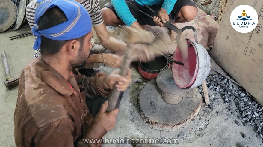 Craftsman hand-hammering a singing bowl on an anvil in Kathmandu